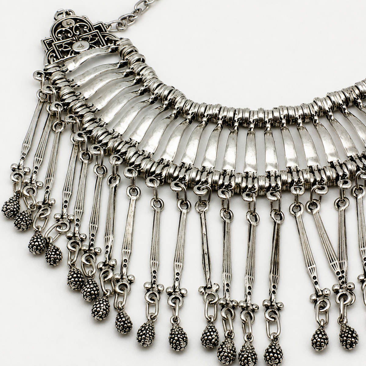 Close view of the necklace’s layered chains and textured fringe details.