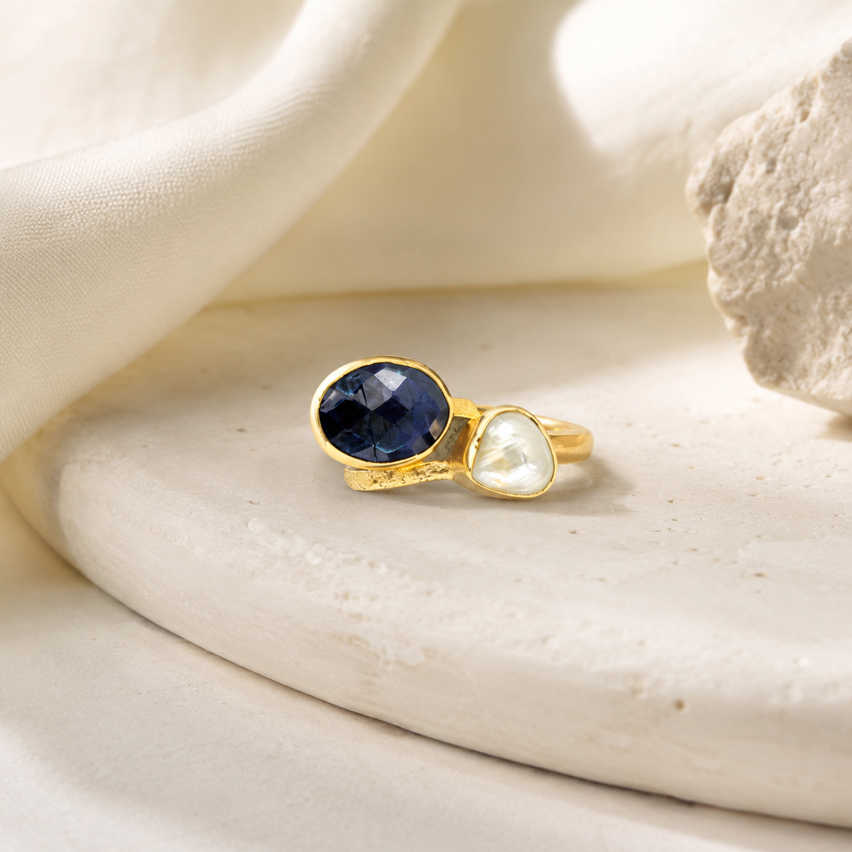Gold-plated ring with two stones in navy blue and white.