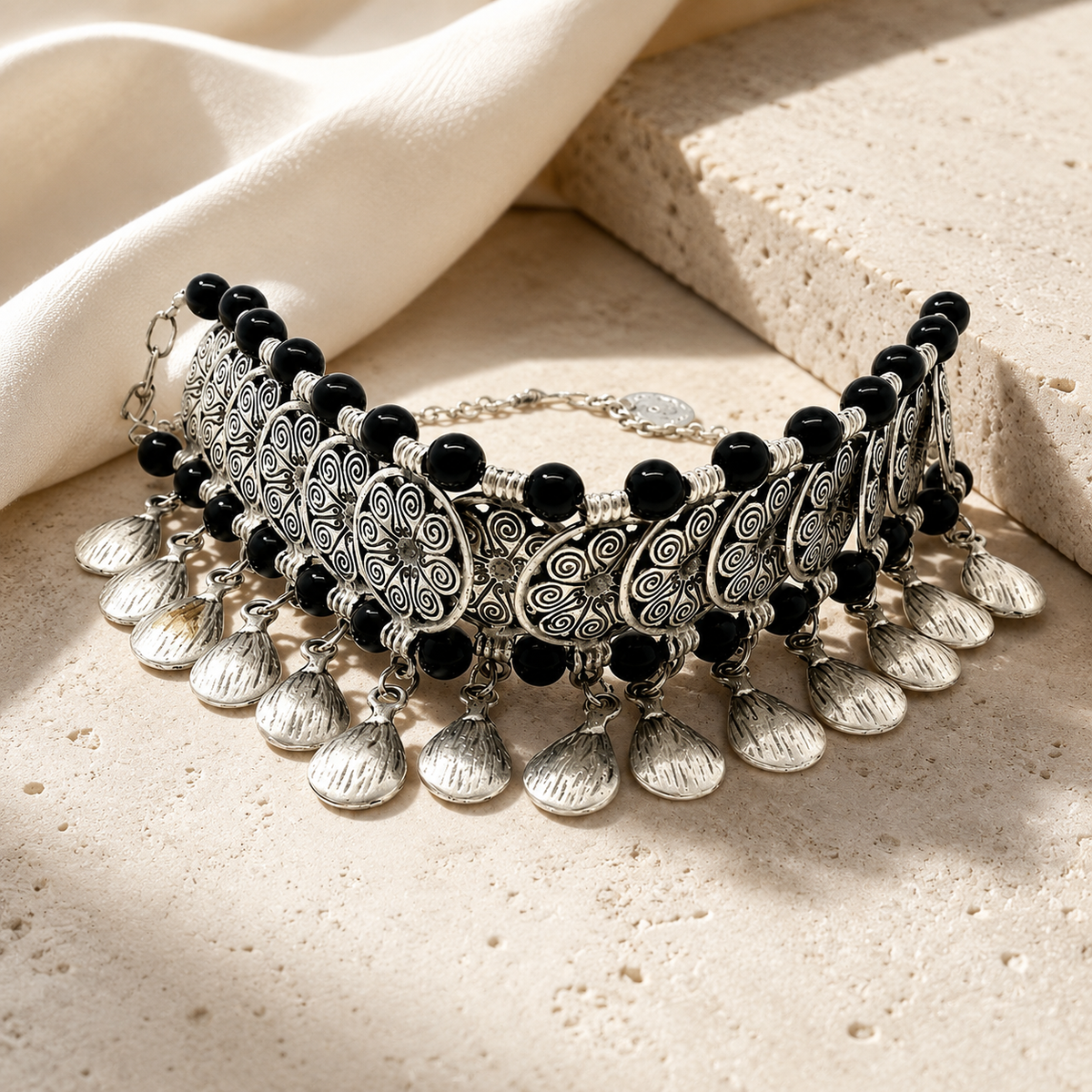 Silver-tone choker necklace with black beads and dangling coin charms.