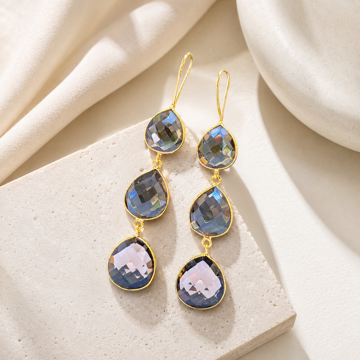 Triple drop earrings with smoky faceted stones and a polished gold-plated look.