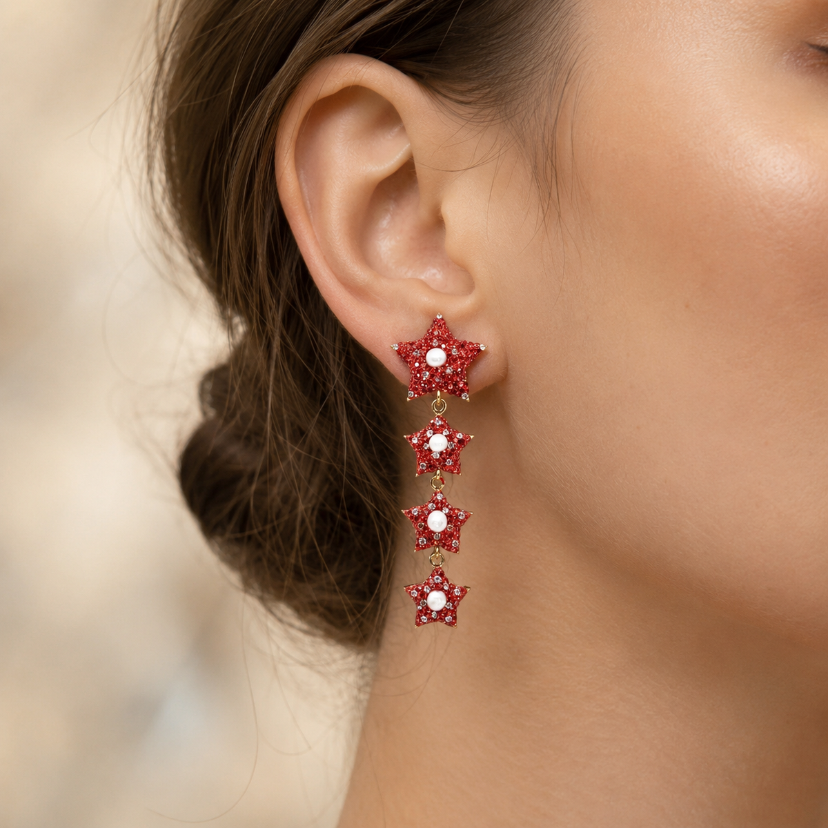 Red star dangle earrings with pearl-like centers and CZ accents shown front view.