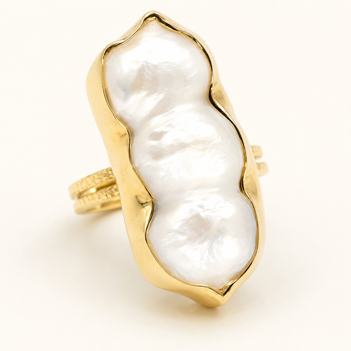 Close-up of the ring's organic pearl-inspired centerpiece and gold-plated setting.