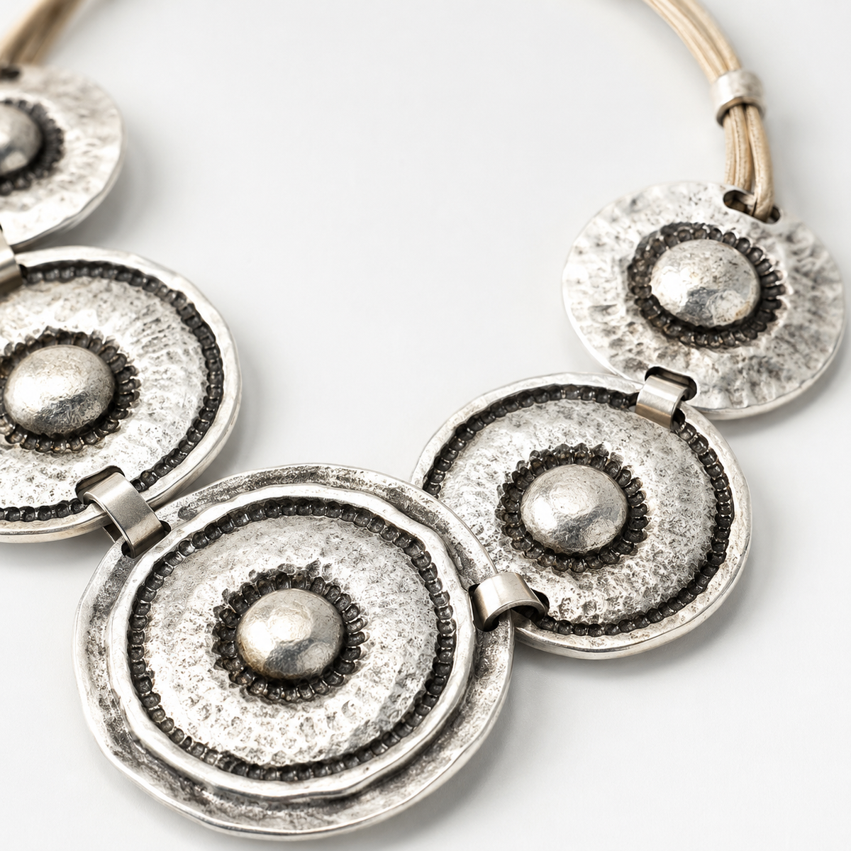Close view of the textured silver-tone circle pendant detail.
