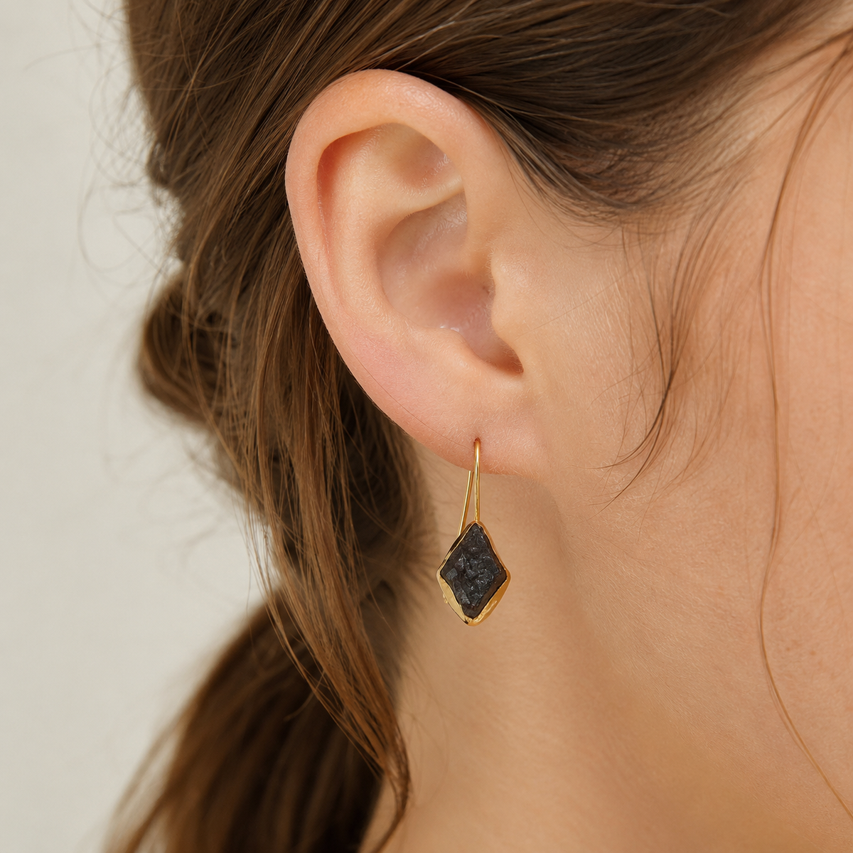 A pair of gold-plated drop earrings with green agate slice stones shown on a white background.