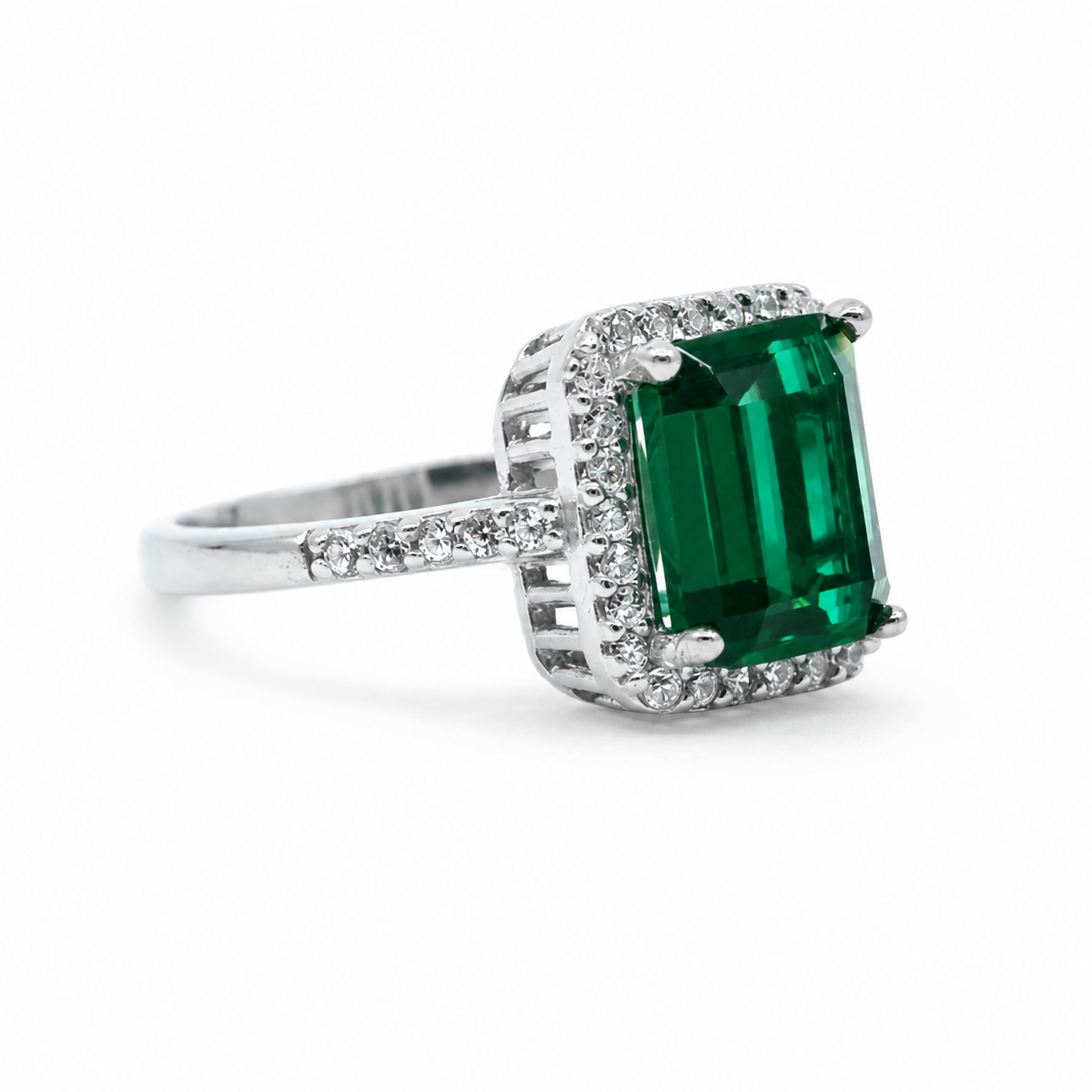 Emerald cut ring with a green center stone and silver-tone accents.