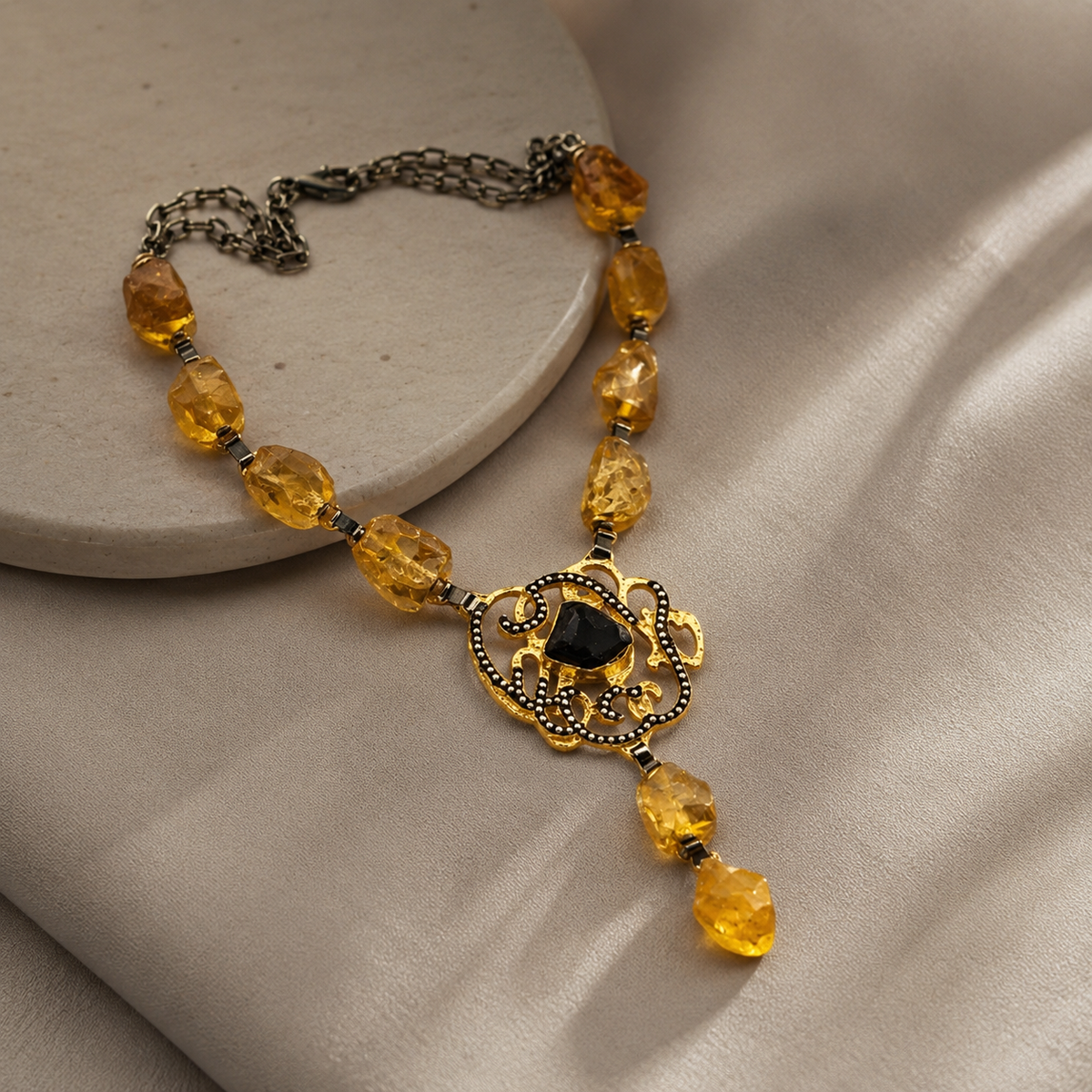 Angled view of the citrine medallion drop necklace with gold-tone details.