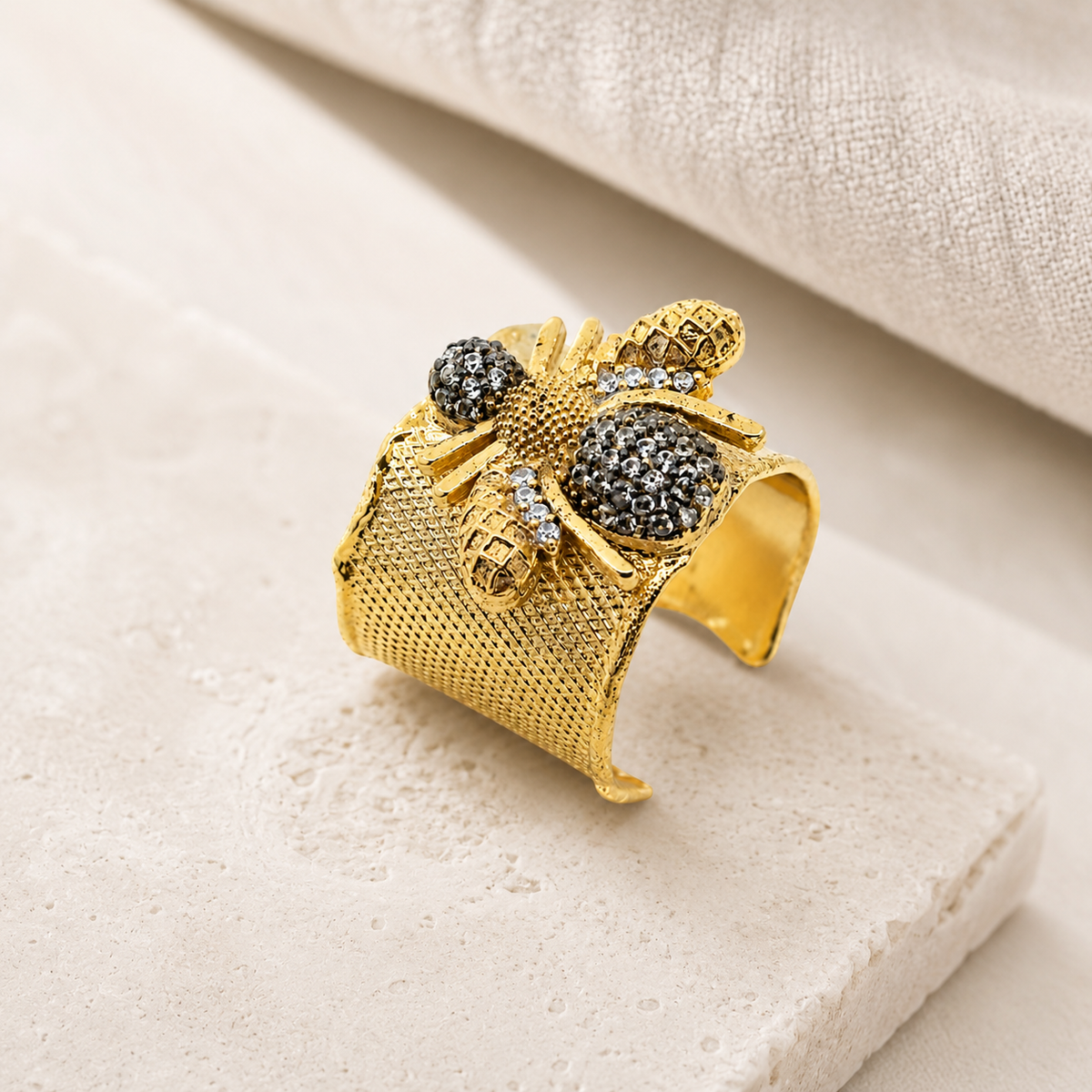 Gold-tone statement cuff ring with a bumble bee motif and textured surface.