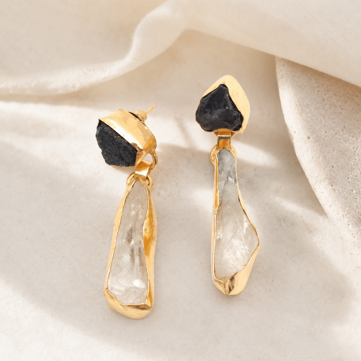 Gold-plated drop earrings with contrasting dark and clear stones.