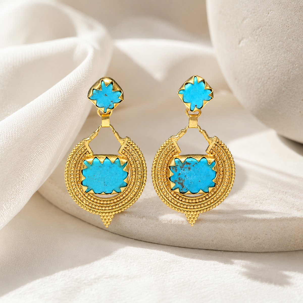 Gold-plated drop earrings with turquoise accents and a decorative frame.