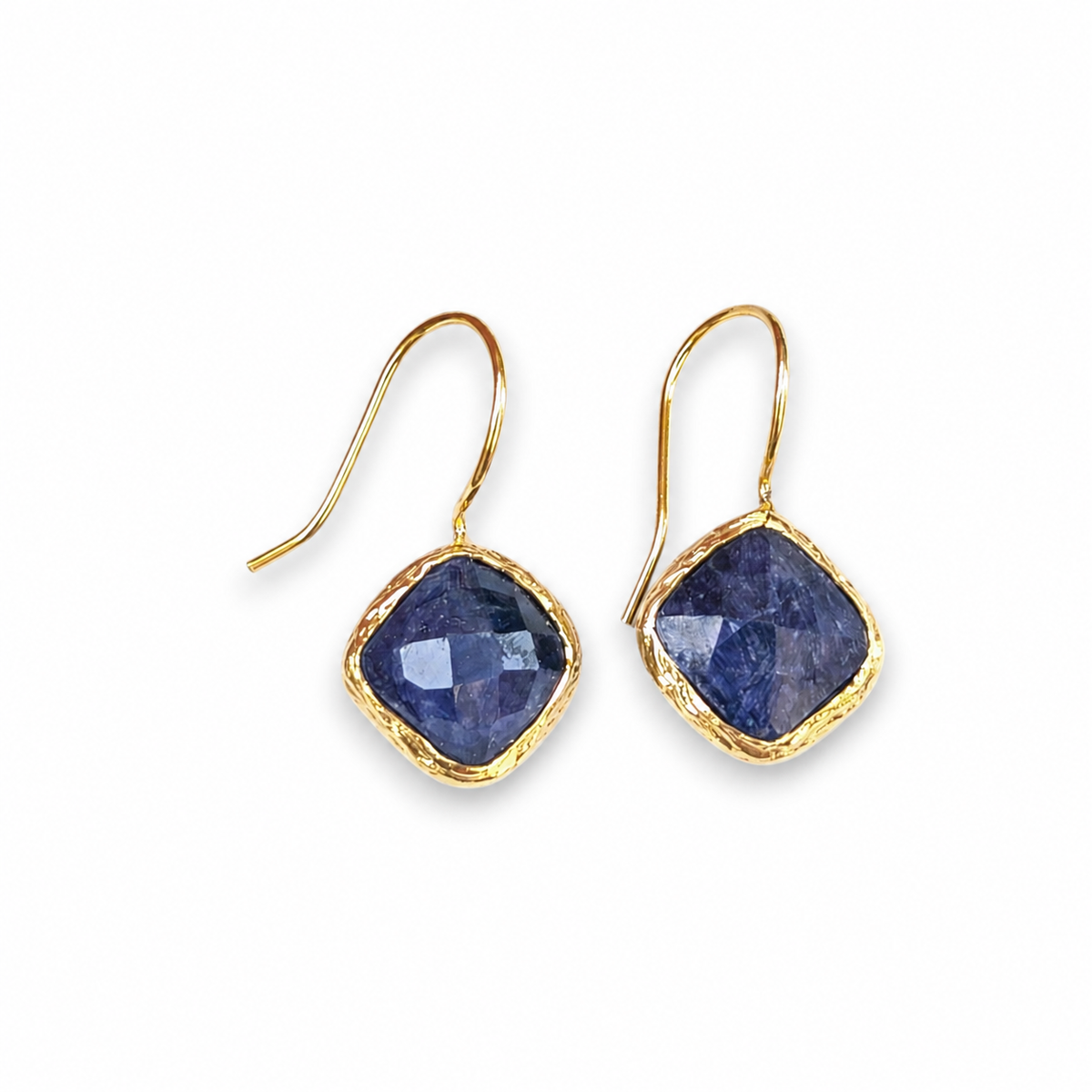 Blue sapphire dangle earrings with a gold-plated frame on a white background.