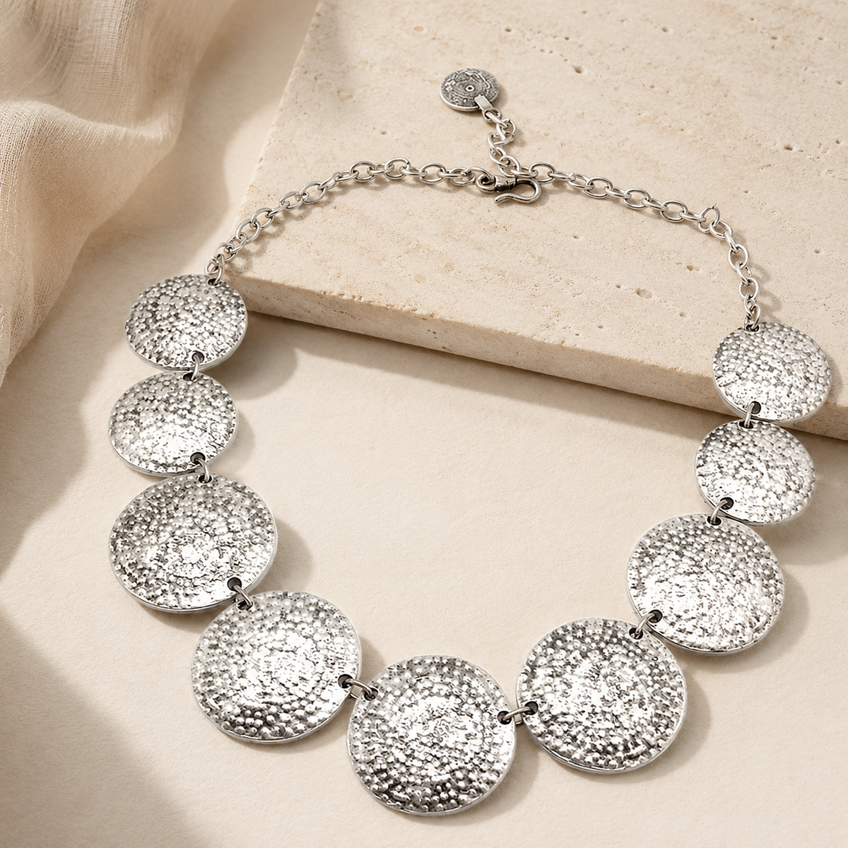 A silver-tone statement necklace with linked hammered discs.
