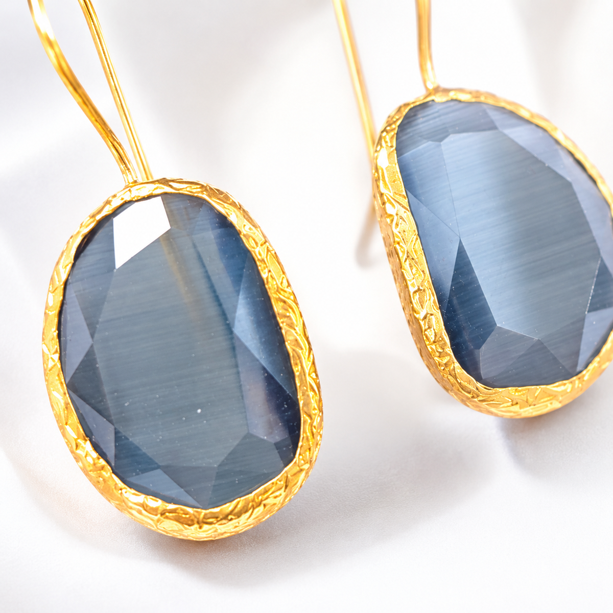 Close view of smoky gray faceted stones and gold-plated edges.