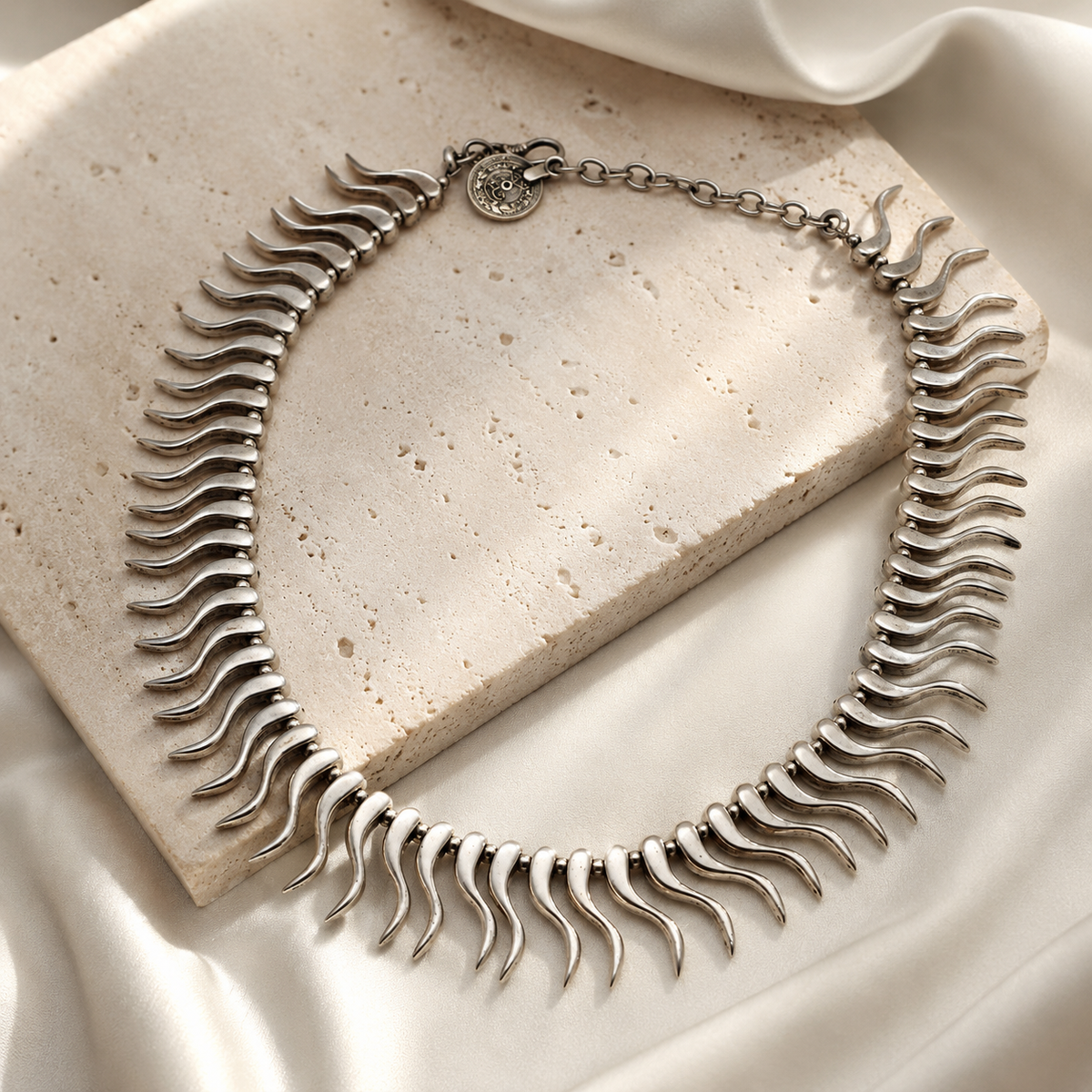 Silver-tone collar necklace with a sculptural curved spike design.