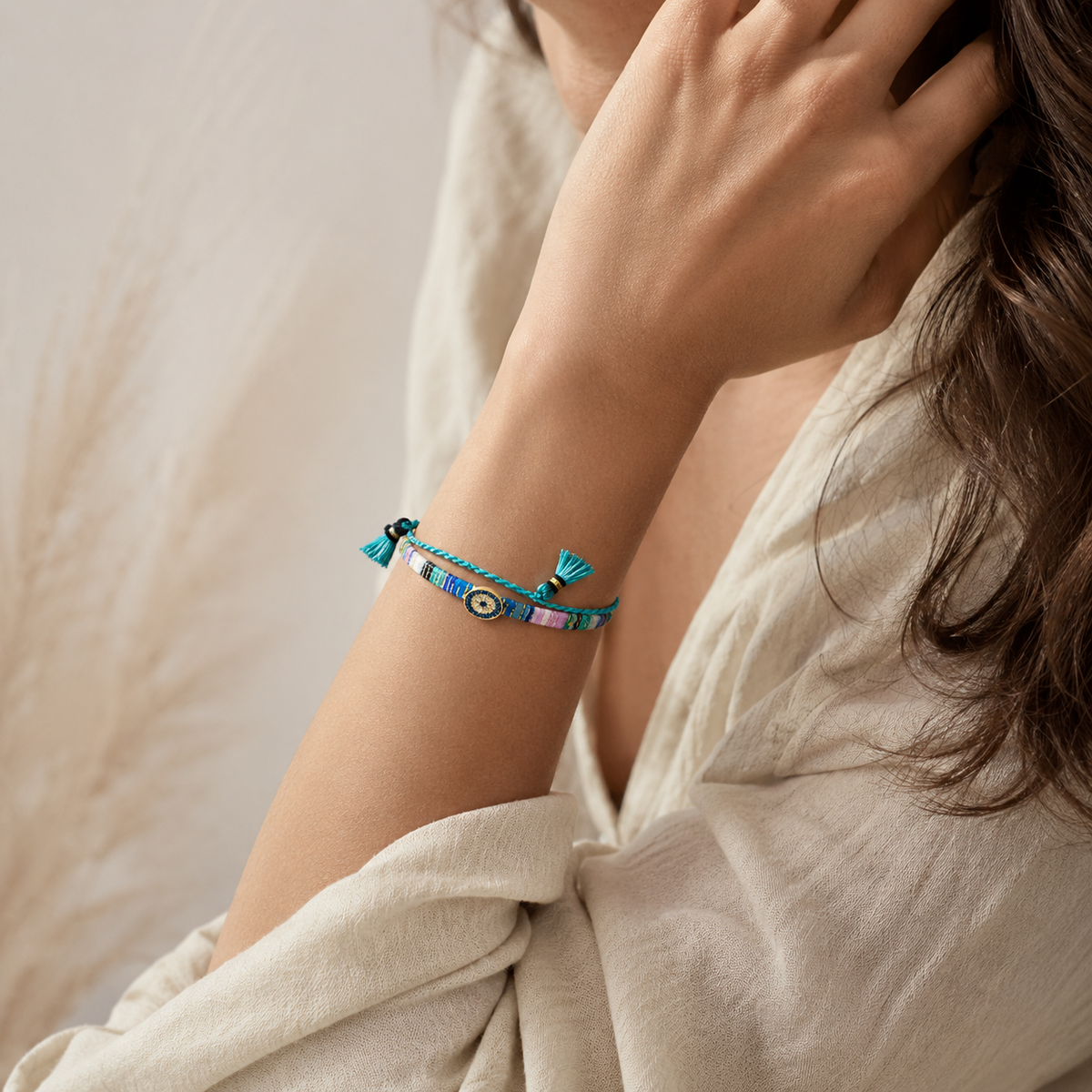 Evil eye bracelet with multicolor woven threads and gold-tone accent.