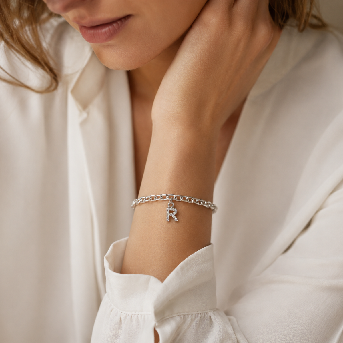 Silver-tone personalized cuff bracelet with a dangling initial charm.