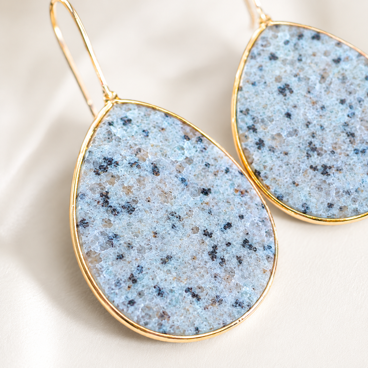 Close view of amazonite earrings with a slim gold frame.