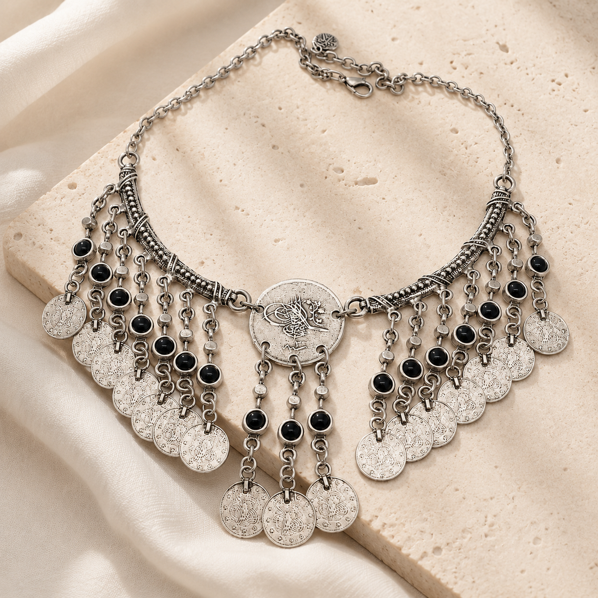 Antique silver fringe necklace with black stone accents styled as a bold statement piece.