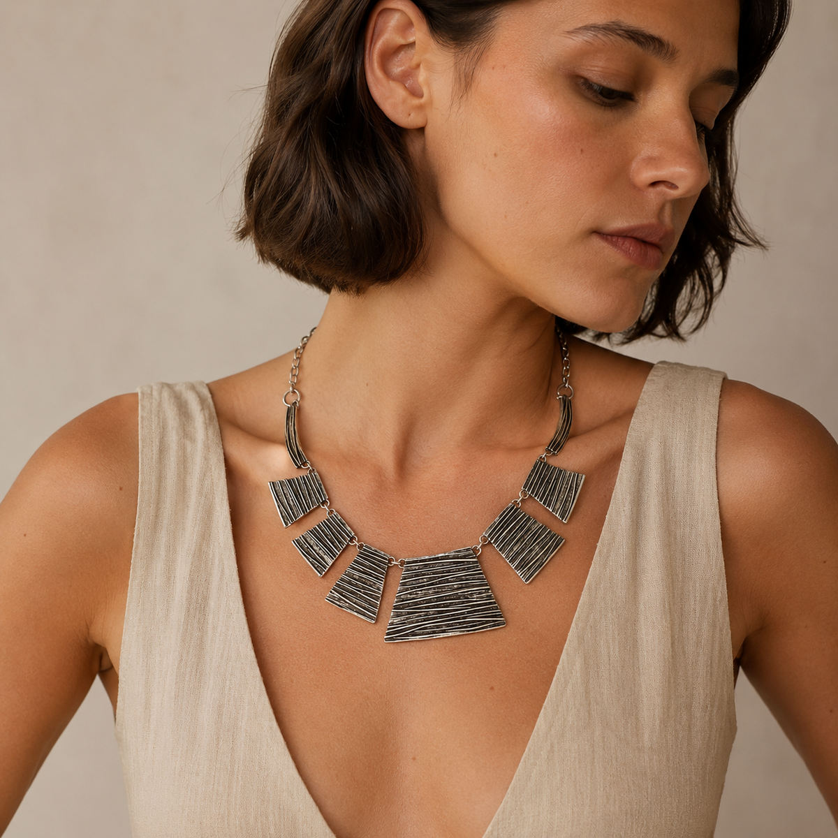 Statement necklace with sculptural silver-tone textured panels.