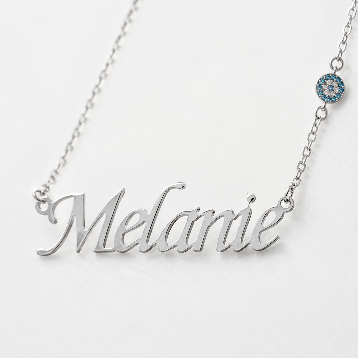 Close view of the engraved script name pendant and blue accent detail.