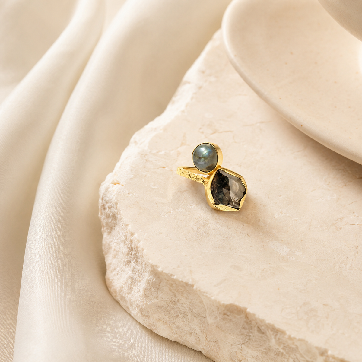 Two-stone gold-plated ring styled on a white background.