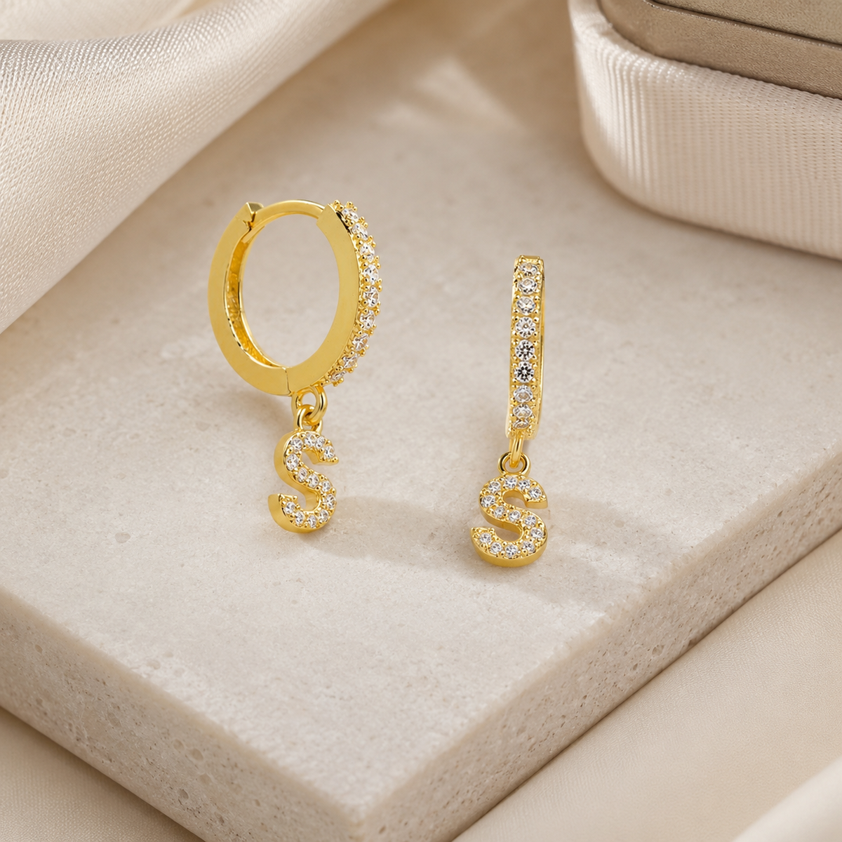 Gold-tone personalized initial earrings with a slim huggie shape and sparkling clear accents.