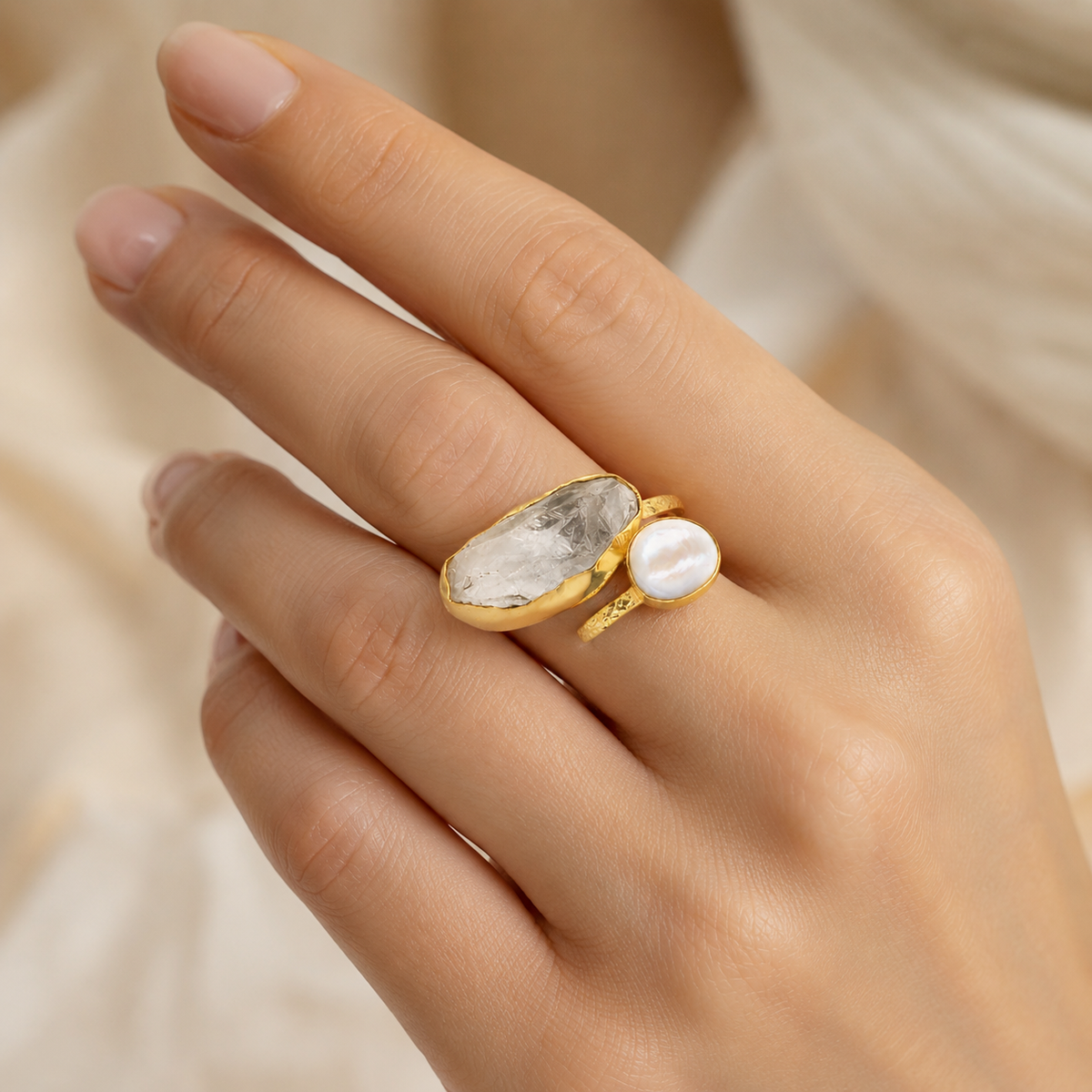 Gold-plated two-stone ring with clear quartz and a pearl-like stone.