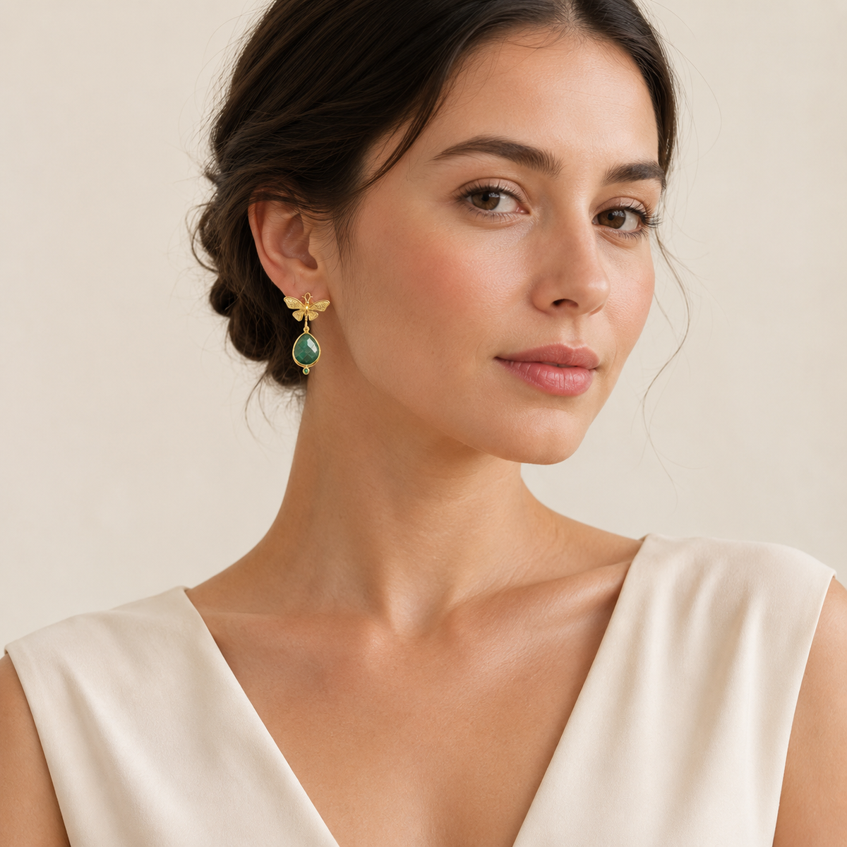 Butterfly drop earrings in gold tone with green teardrop accents.