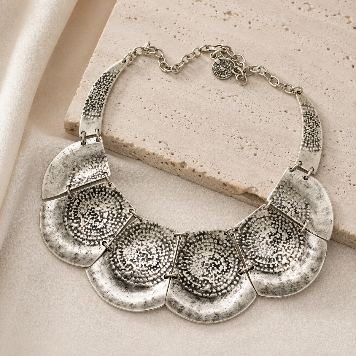 Silver hammered plate necklace with a bold layered silhouette.
