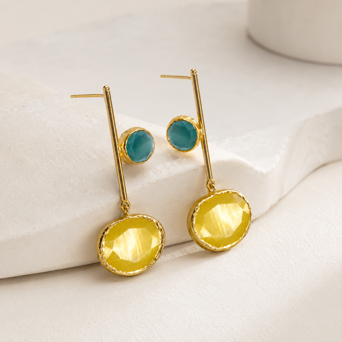 Angle view of mustard yellow drop earrings with faceted stones and gold-tone finish.