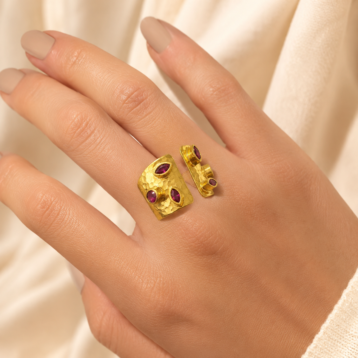 Gold-plated open cuff ring with cherry-toned CZ stones shown from the front.