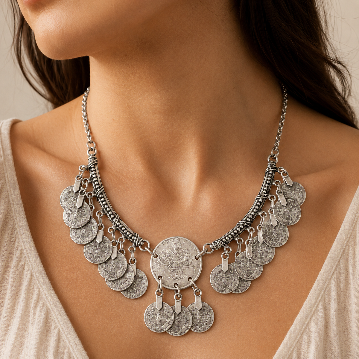 Silver-tone crescent pendant necklace with coin fringe shown from the front.