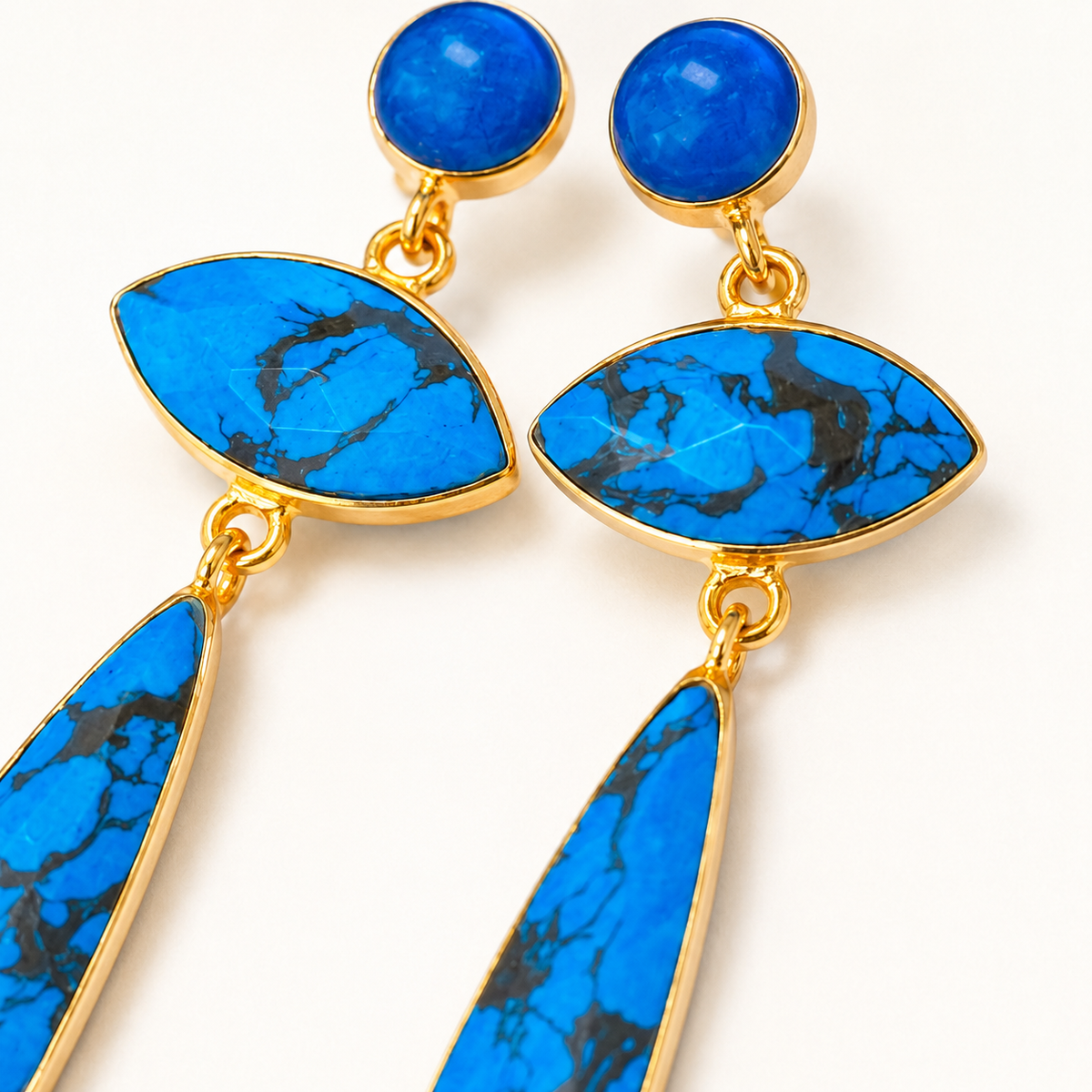 Close view of the turquoise stone details and gold-plated edges on the earrings.