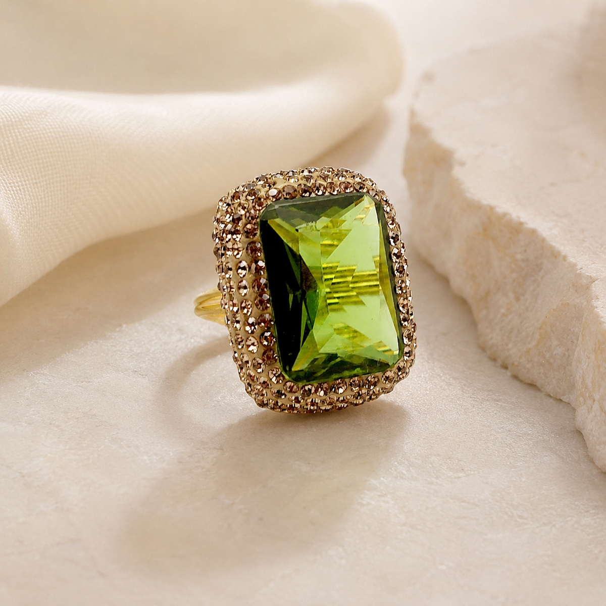 A bold gold-tone ring with a large octagon green stone.