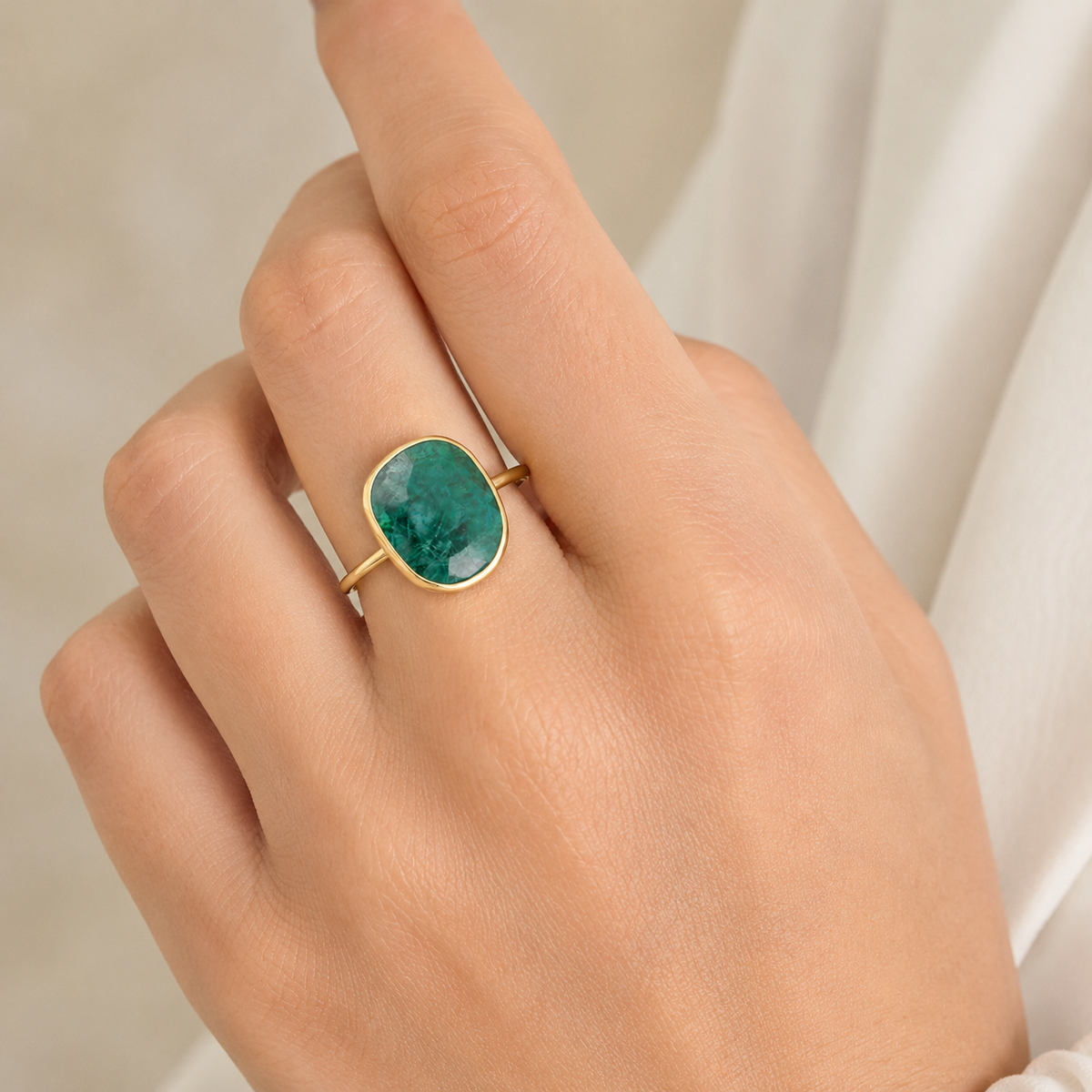Emerald green oval statement ring shown from the front.