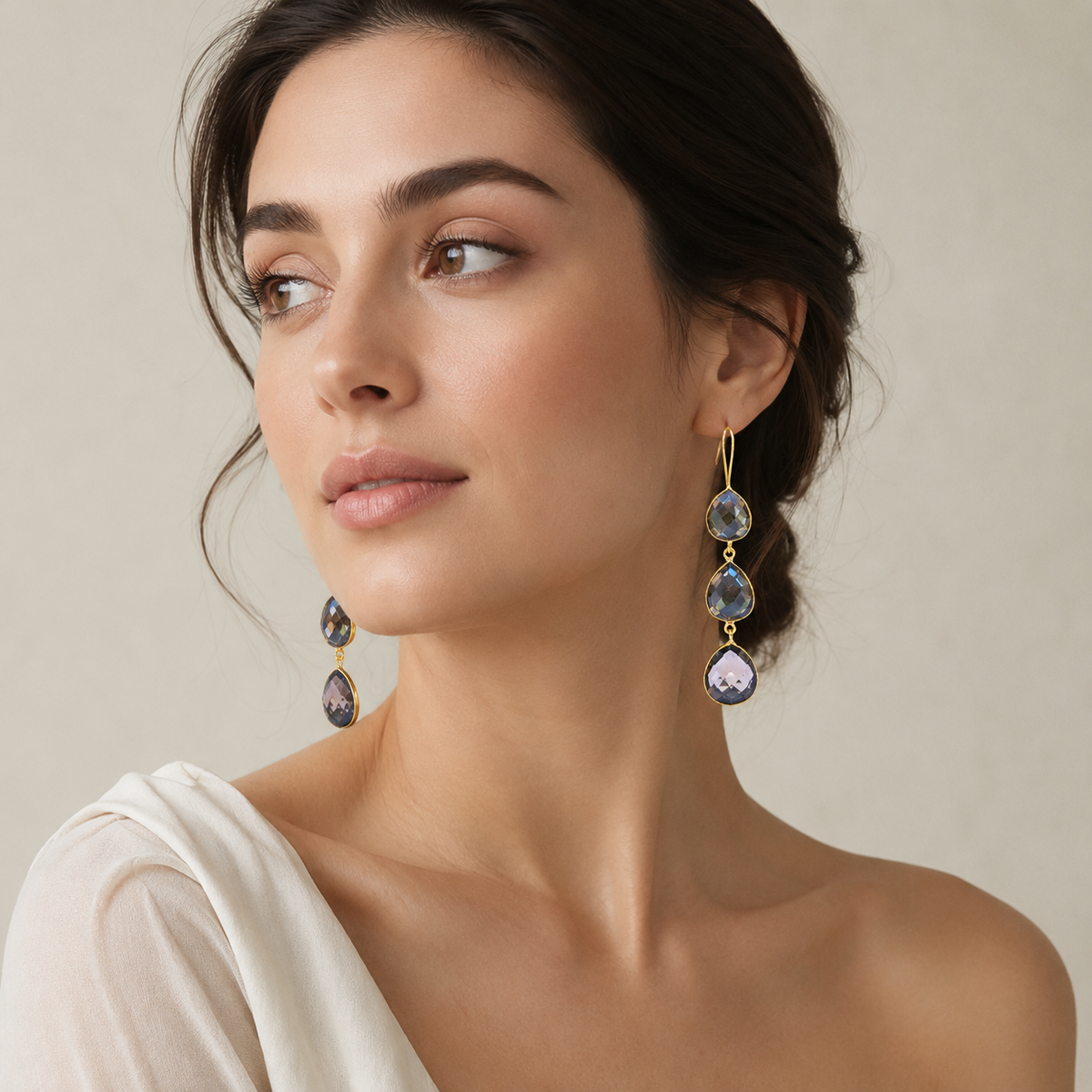 Pair of smoky quartz teardrop earrings with a faceted finish and gold-plated frame.