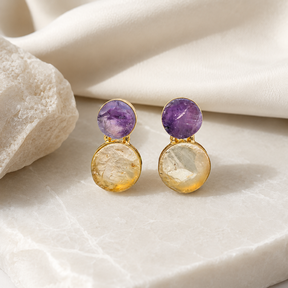 Gold-plated drop earrings with purple amethyst and clear quartz in a layered design.
