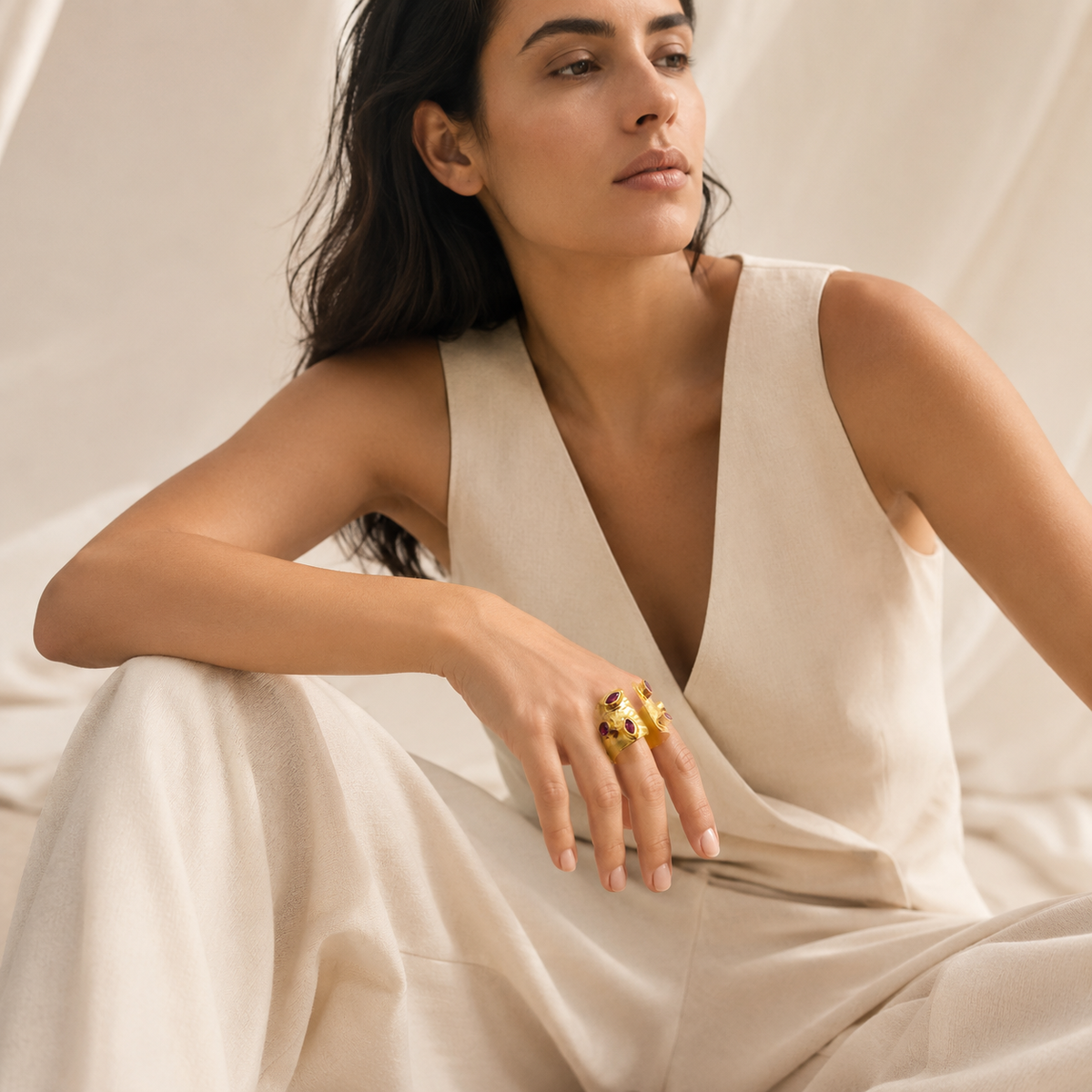 Gold-plated open cuff ring with a sculptural shape and cherry-toned stones.