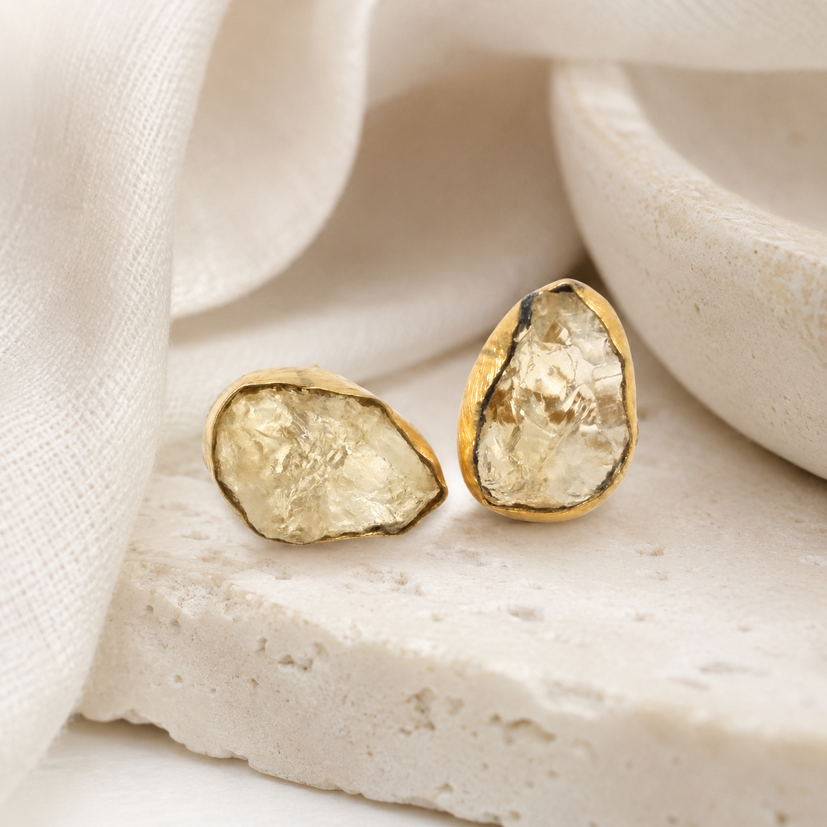 Raw quartz stud earrings with a softly textured gold-plated edge.