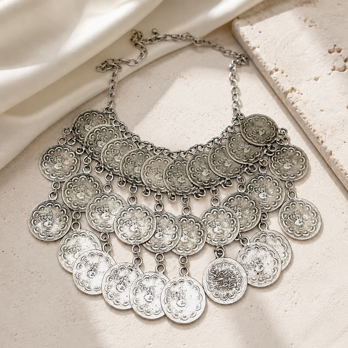 Silver-tone layered bib necklace with multiple dangling coin discs.