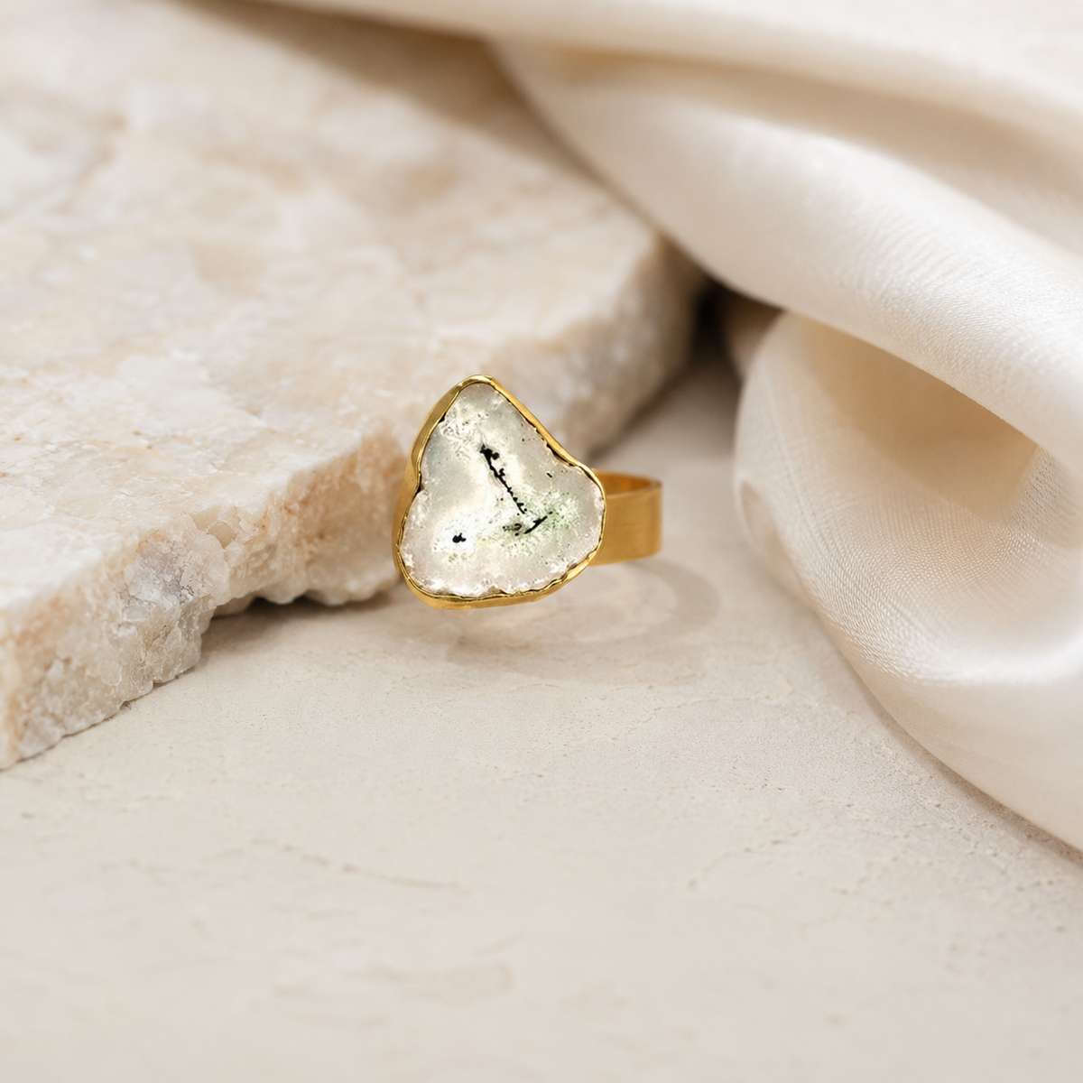 Gold-plated ring with a freeform solar quartz slice and soft natural tones.