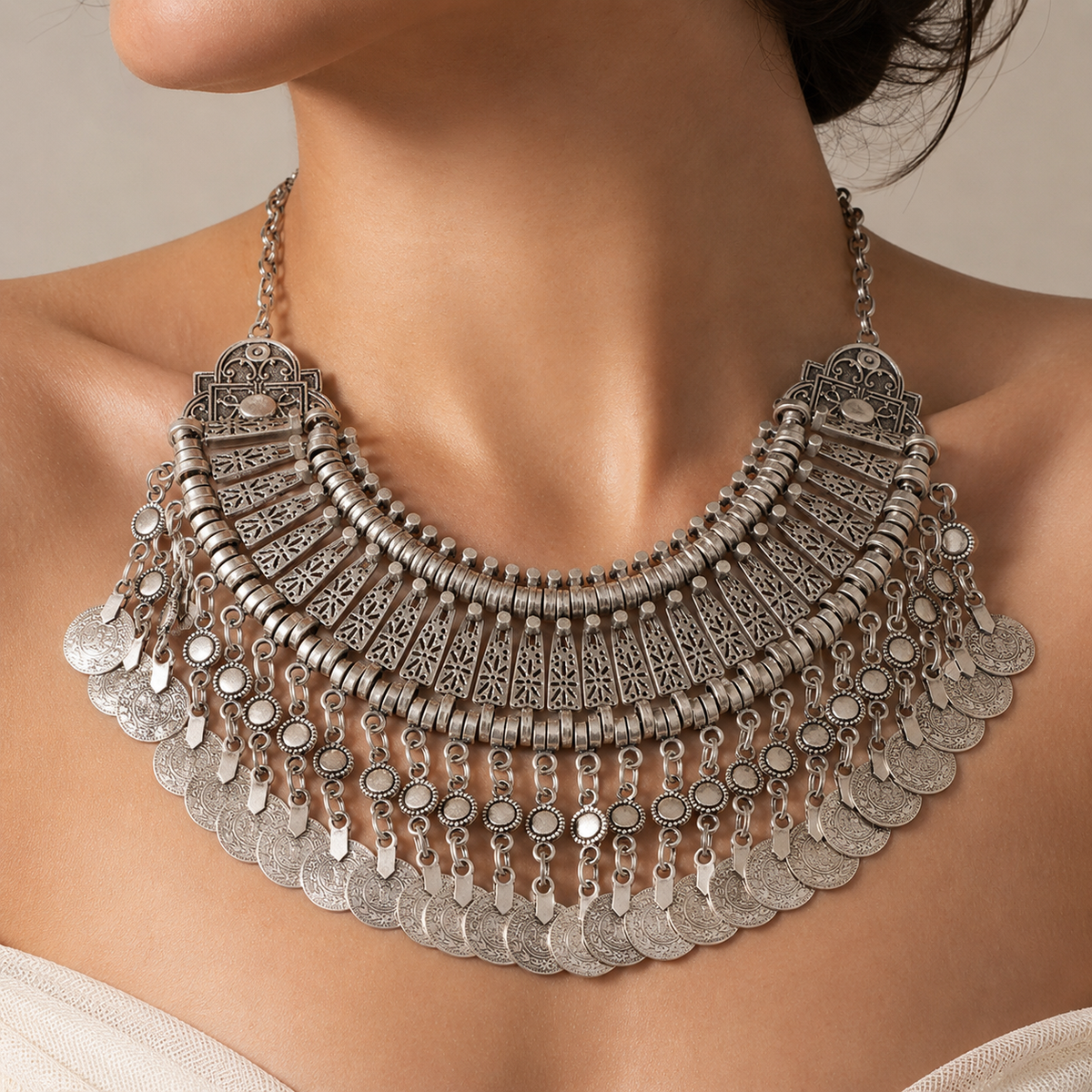 Silver-tone boho bib necklace shown front view with coin fringe and ornate details.