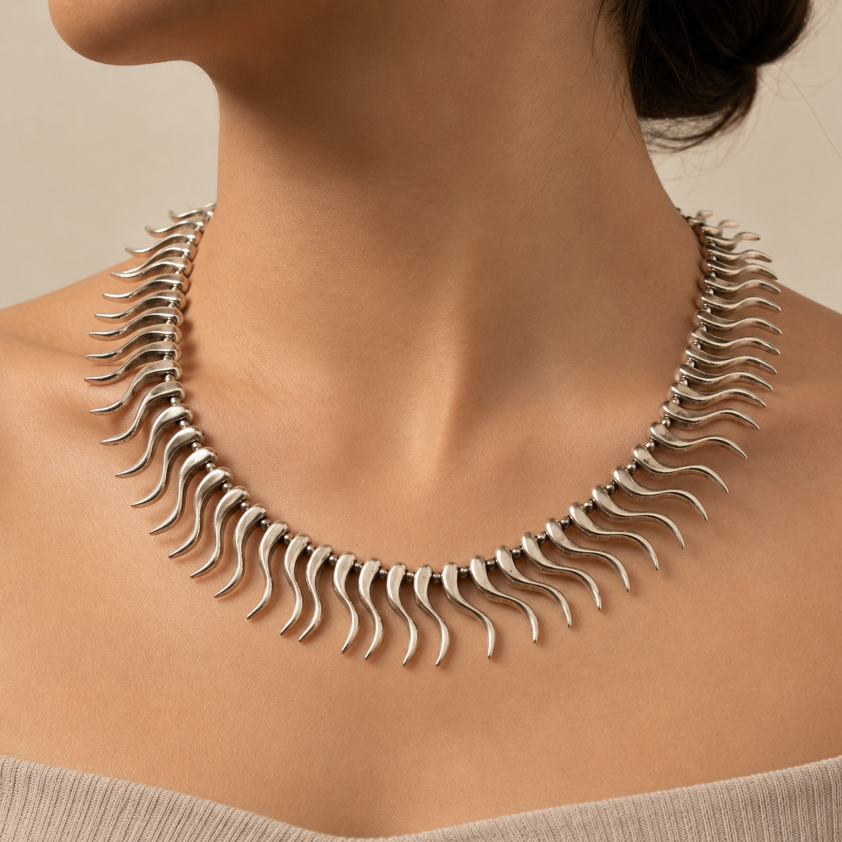 Silver-tone curved spike collar necklace shown from above on a white background.