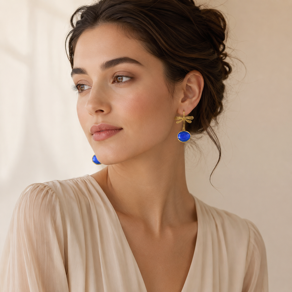 Gold-plated earrings with dragonfly tops and bright blue drops.