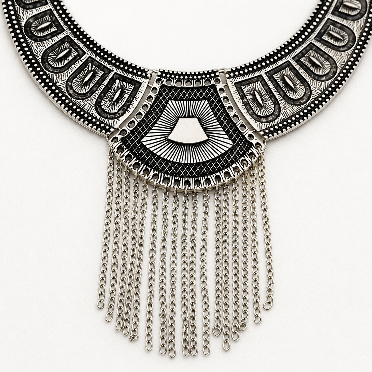 Close view of the necklace's textured black panels and chain fringe.