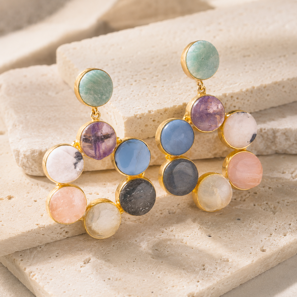 Gold-tone statement earrings with colorful round gemstone-style stones arranged in a hoop shape.