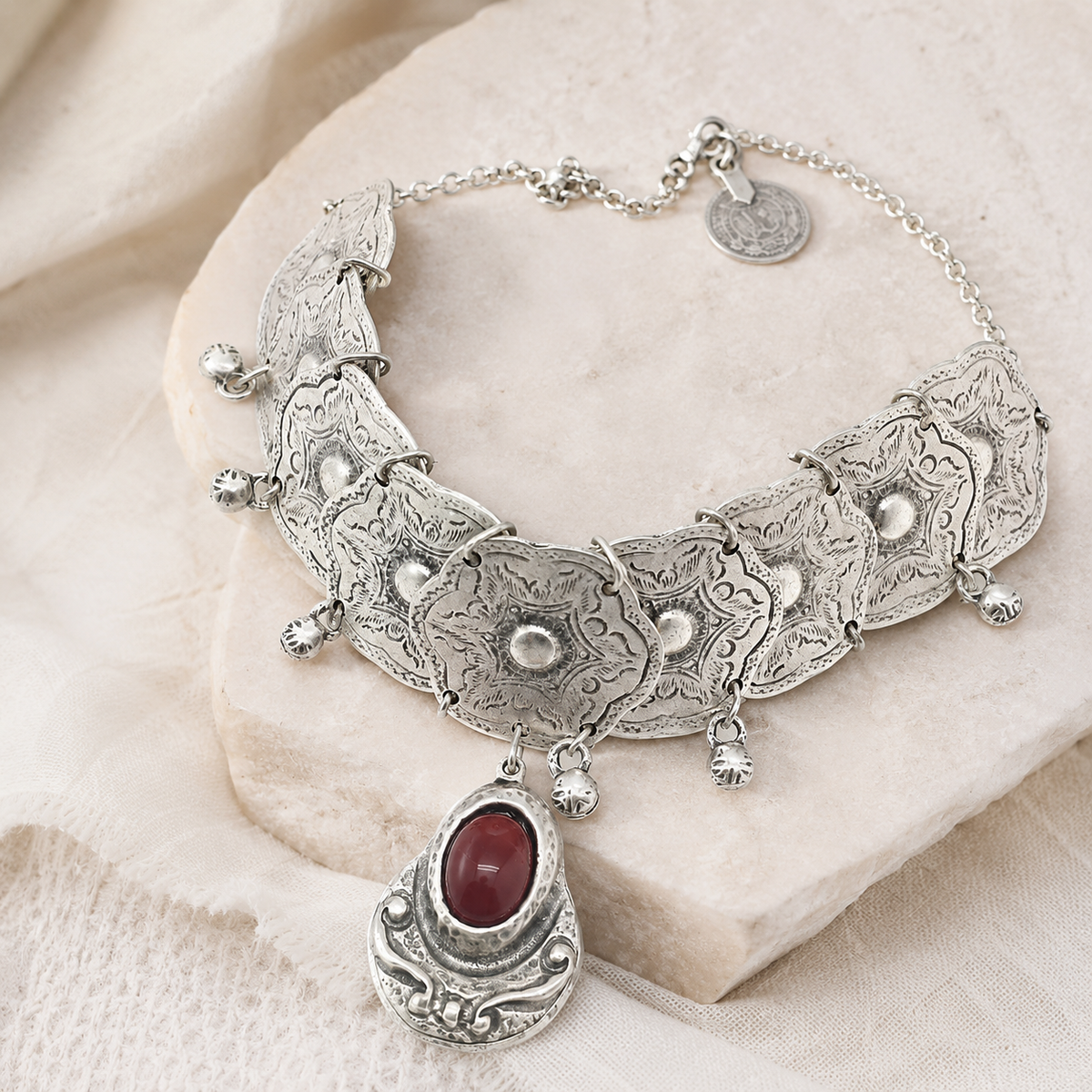 Silver-tone statement choker necklace with a red stone drop.