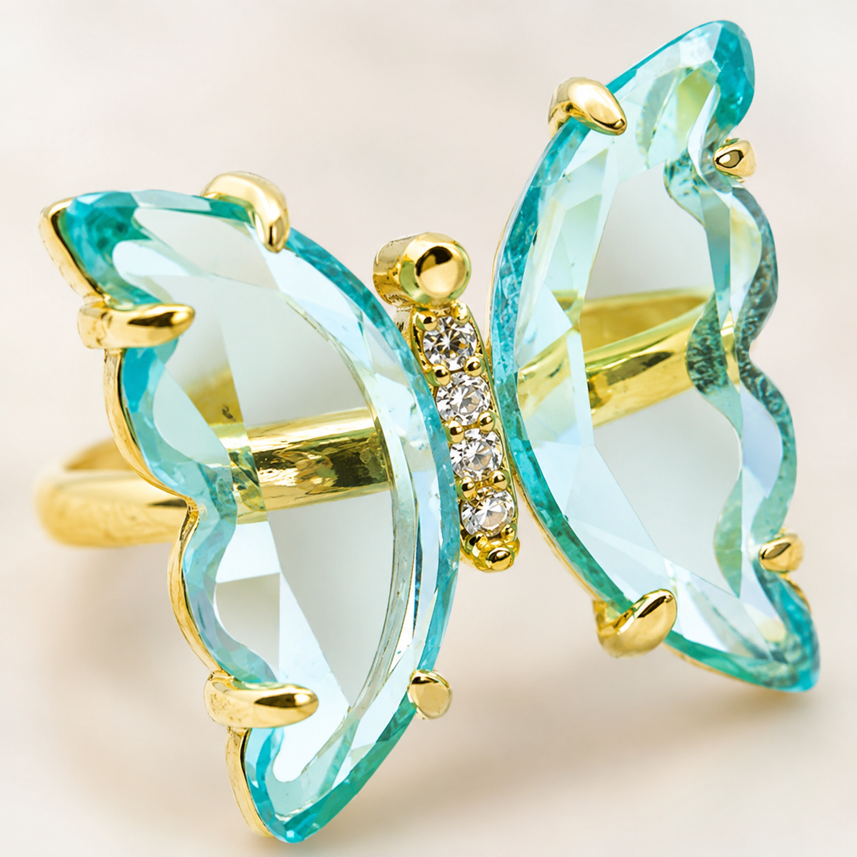 Close view of a butterfly ring with sky blue topaz and small CZ stones.
