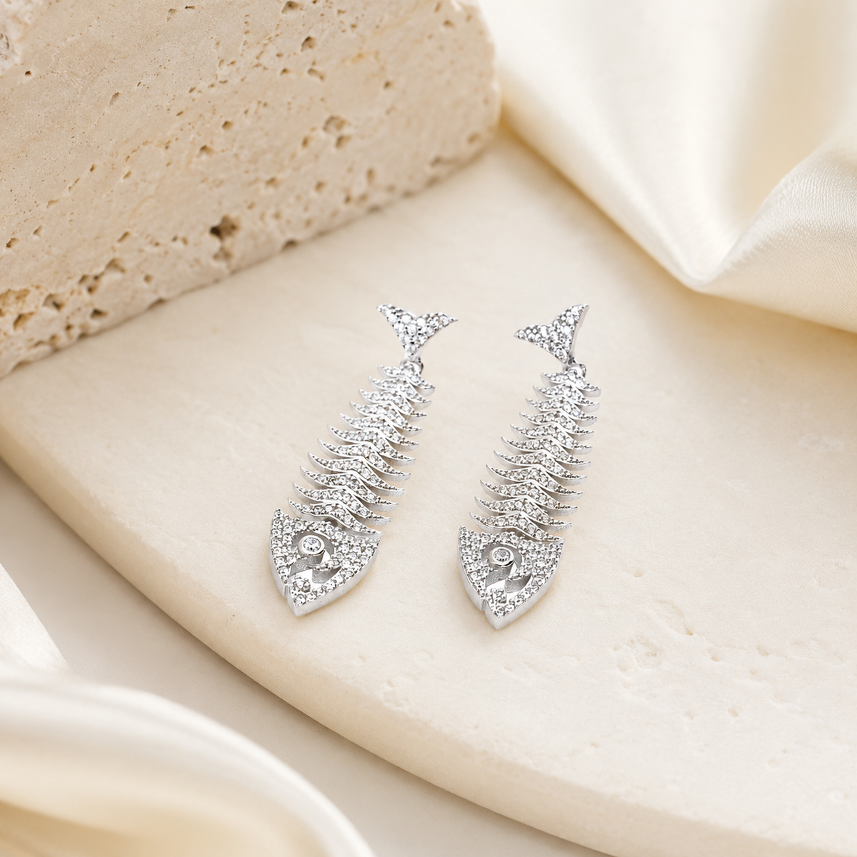 Silver fish bone drop earrings with a sculptural shape and sparkling finish.