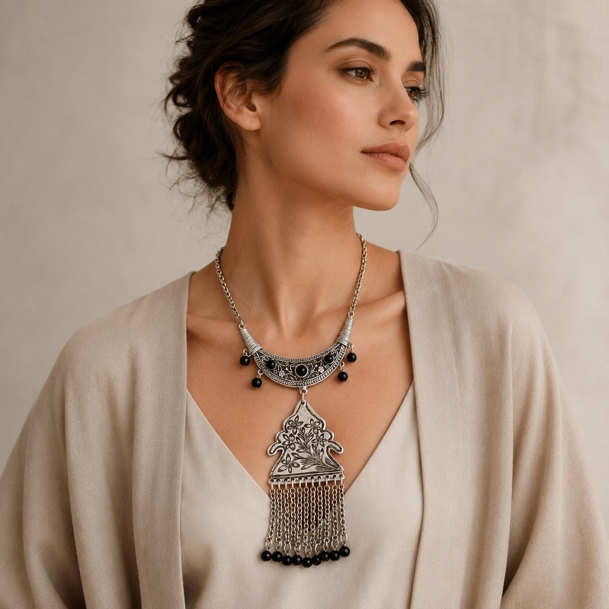 Black bead pendant necklace with ornate floral detailing.