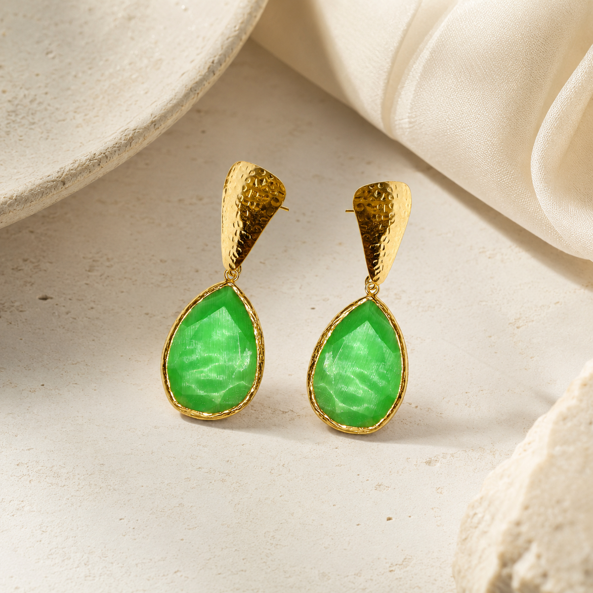 Green teardrop earrings with a textured gold finish, shown from the front.